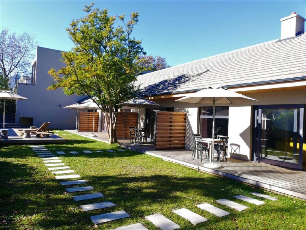 een achtertuin met een tafel en een paraplu bij De Haas Living @ Die Laan 2 in Stellenbosch