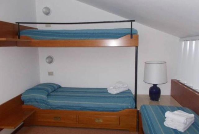 En eller flere senge i et værelse på Appartamento nel residence i Boboli a Punta Ala