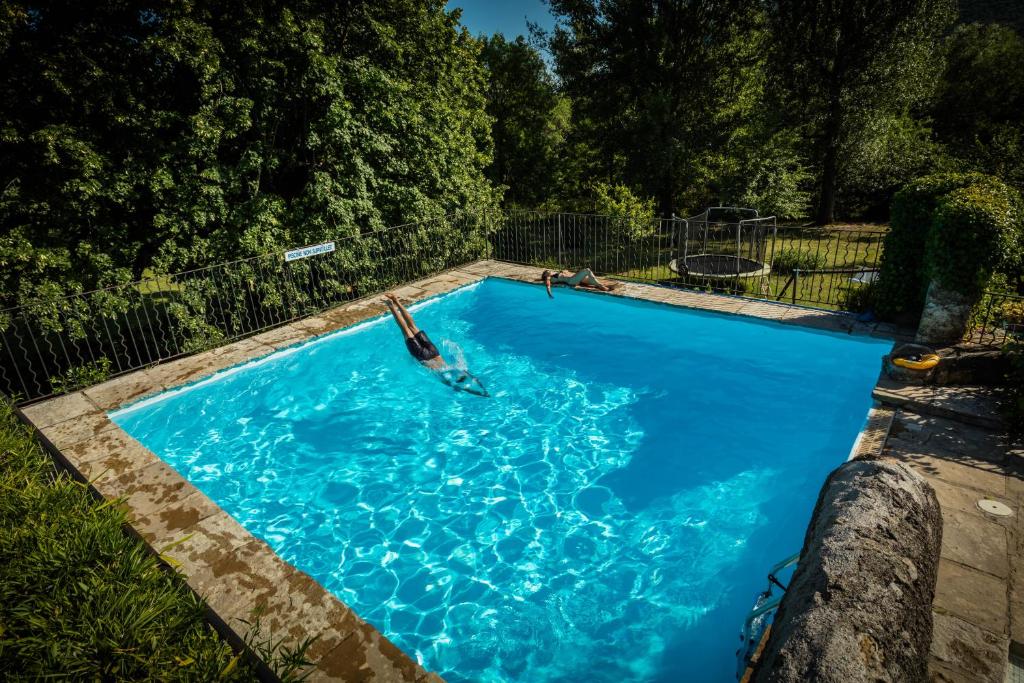 ein Pool mit einer Person im Wasser in der Unterkunft Logis des Magnans - le Murier - in Sauve