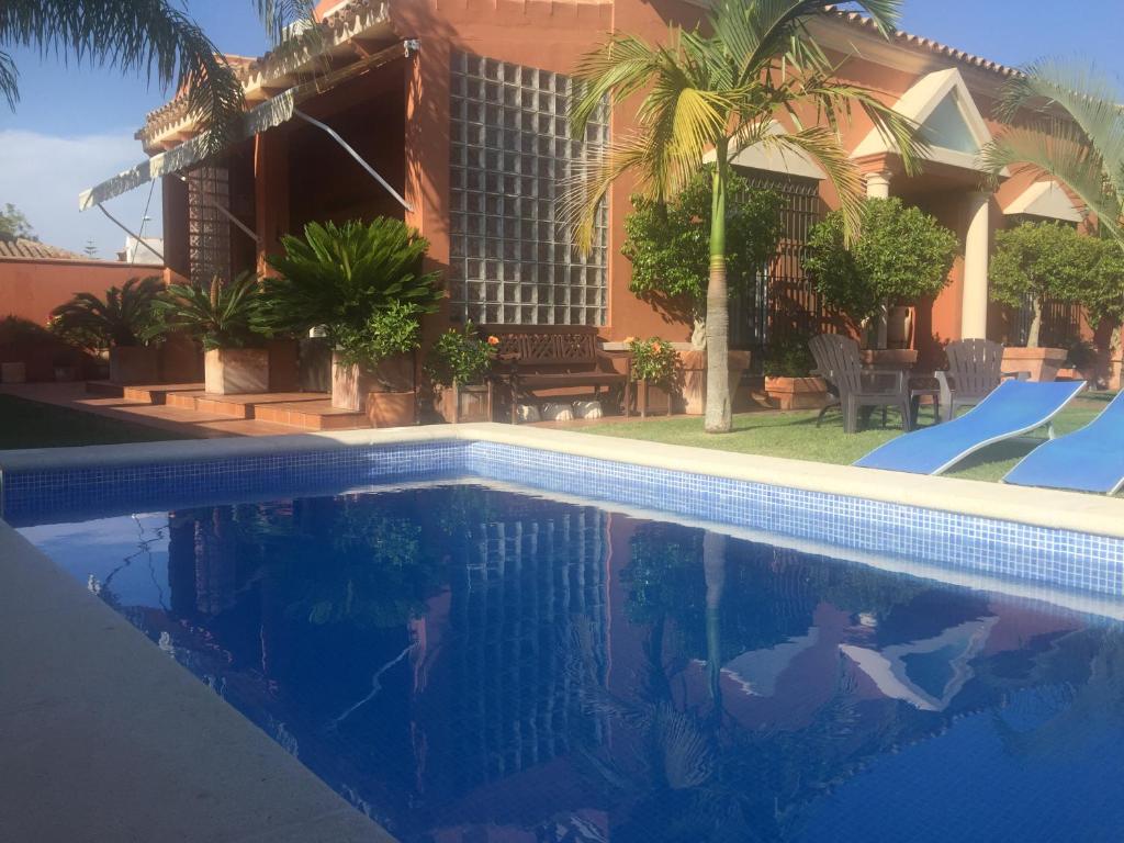 a swimming pool in front of a house at Chalet Martin in Chiclana de la Frontera