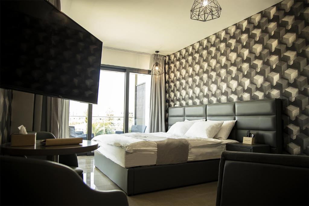 a bedroom with a bed and a large window at Jimmy's Suites in Larnaca