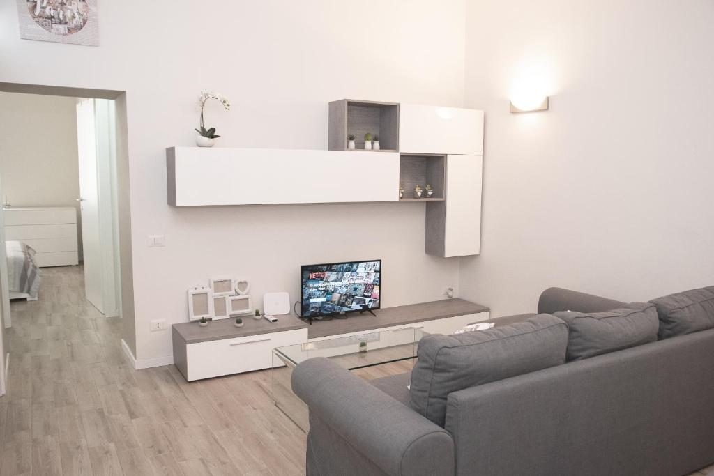 uma sala de estar com um sofá e uma televisão de ecrã plano em La Dimora del Cardinale em Roma
