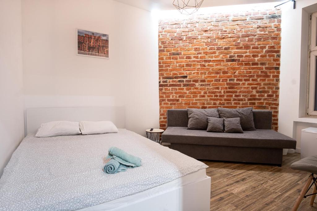 ein Schlafzimmer mit einem Bett und einer Ziegelwand in der Unterkunft Dream Aparts-Rewolucji 2 in Łódź