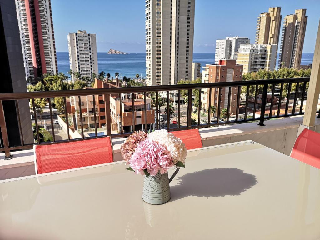 a vase of flowers sitting on a table on a balcony at CASA MARCOS in Benidorm