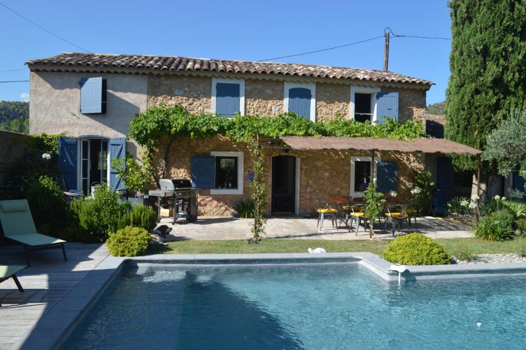 uma villa com piscina em frente a uma casa em Le Majalou em Villecroze