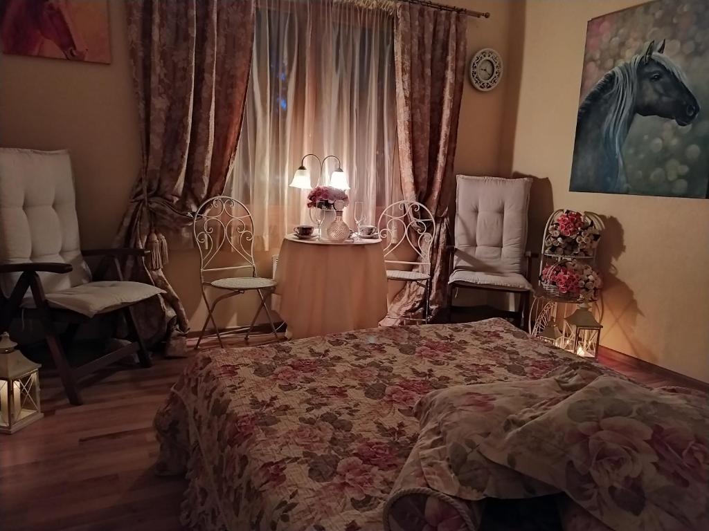 a bedroom with a bed and two chairs and a window at Jumpravas pils in Jumprava