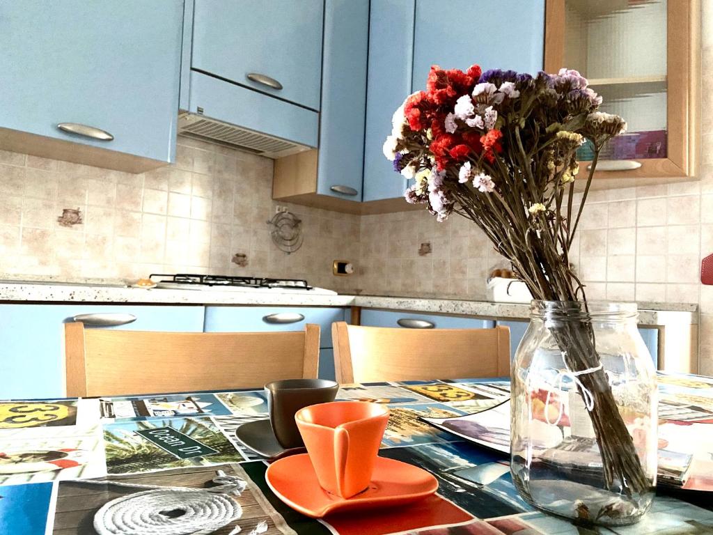 una mesa con un jarrón de flores en una cocina en Ciao MARE, en Vasto