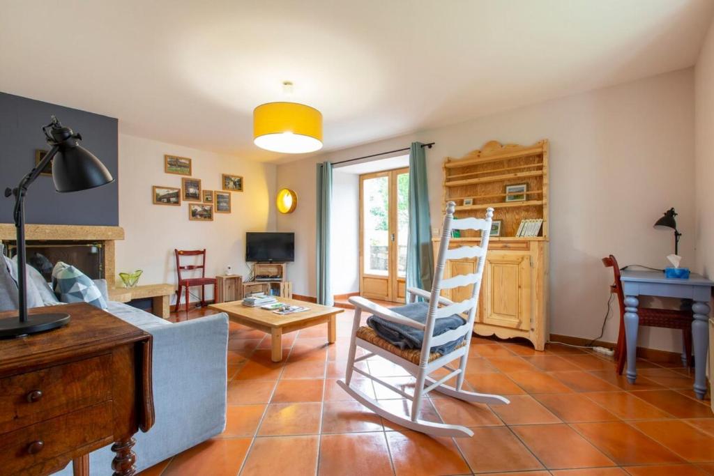 uma sala de estar com uma cadeira e uma mesa em La Bergerie apartment in an old farmhouse! em Nâves-Parmelan