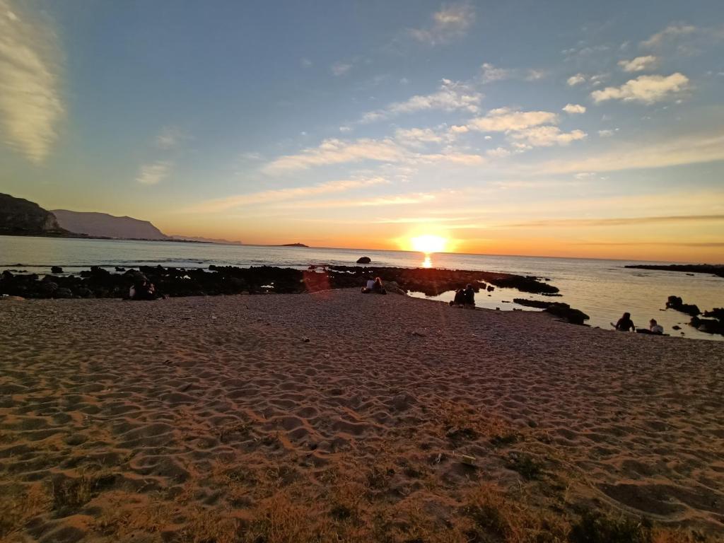 a sunset on a beach with the sun setting at La Casetta di Nonna Anna in Palermo