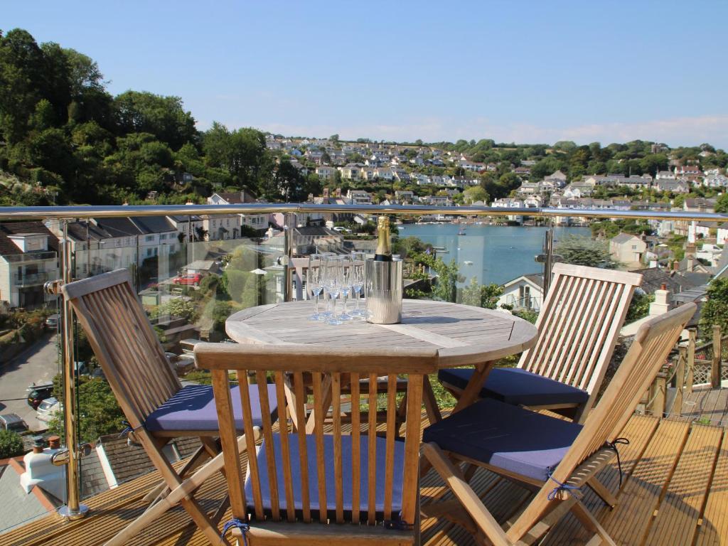 een houten tafel en stoelen op een balkon met uitzicht bij Kittiwake in Plymouth