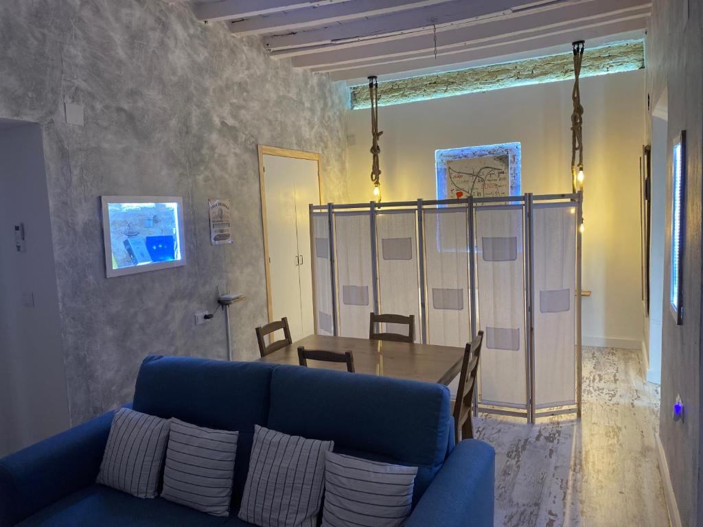 ein Wohnzimmer mit einem blauen Sofa und einem Tisch in der Unterkunft LA CUEVA DEL LOCO, Bretones 29 in Sanlúcar de Barrameda