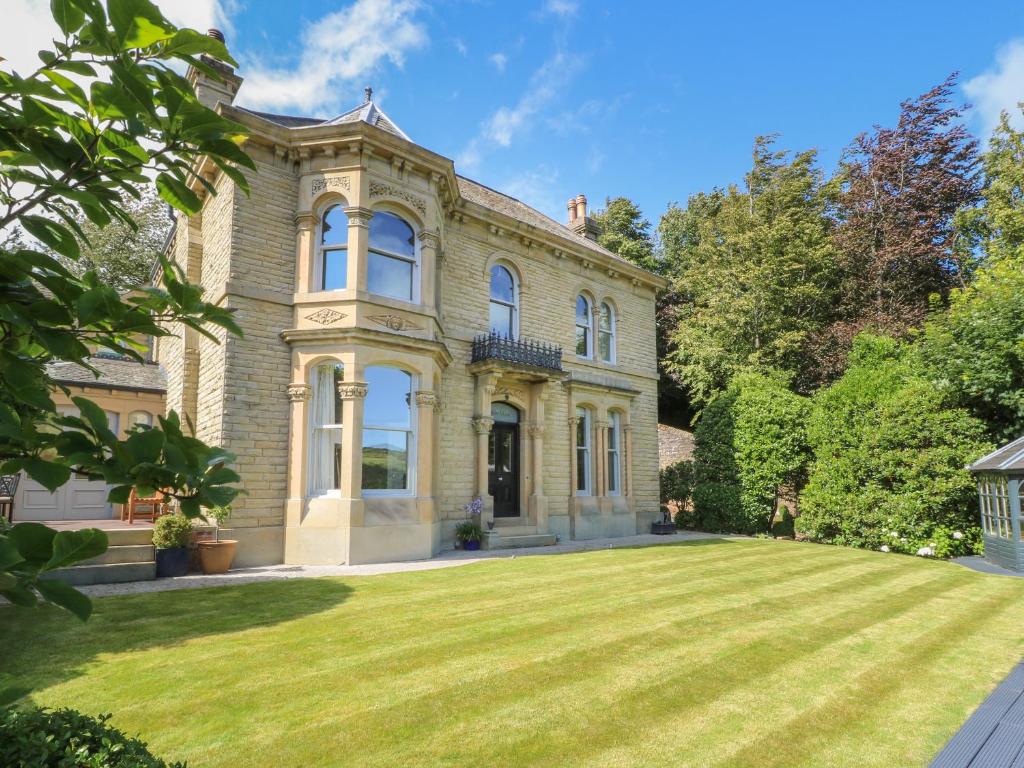 een groot bakstenen huis met een grote tuin bij Ash Villa in Holmfirth