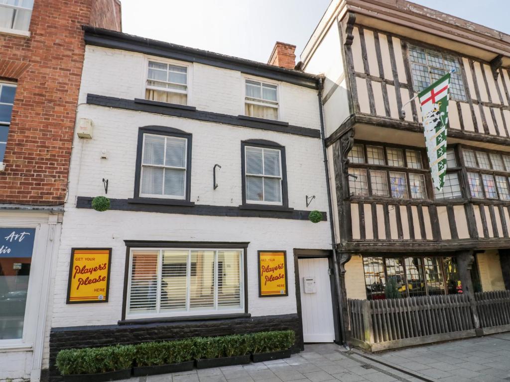 uma casa branca com um edifício a preto e branco em The Old Paper Shop em Tewkesbury