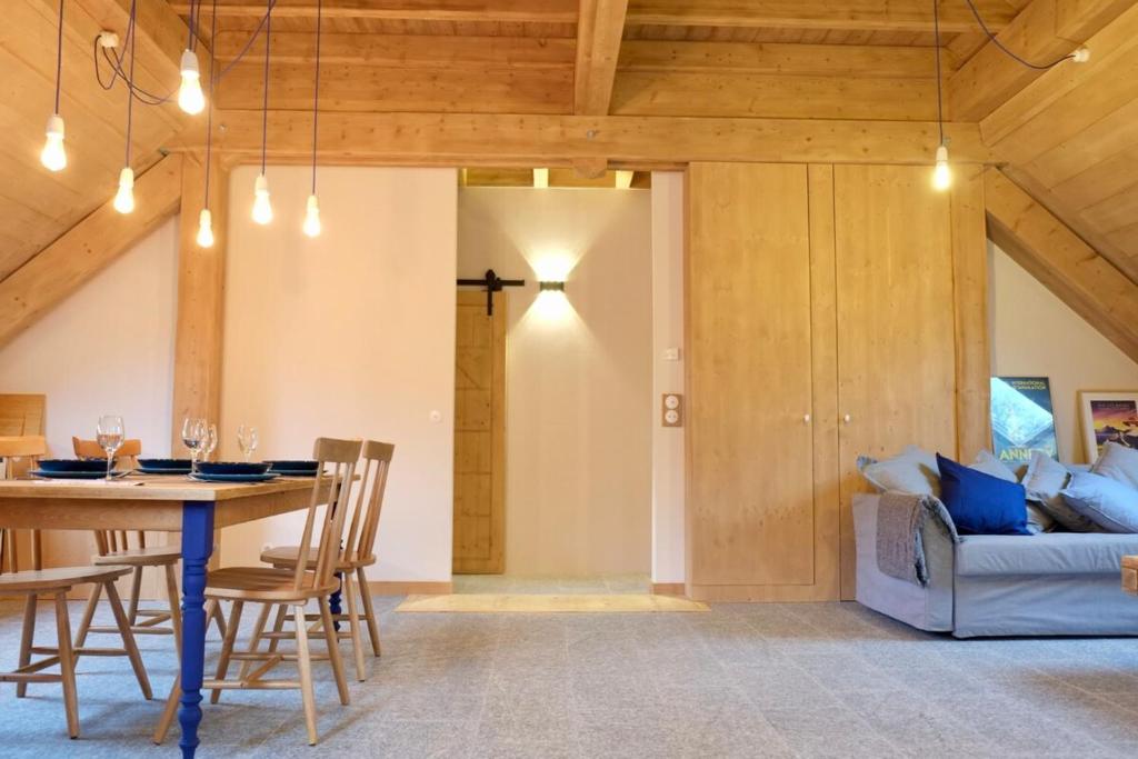 ein Esszimmer mit einem Tisch und einem Sofa in der Unterkunft L'Alpage de la Bergerie apartment in a cosy farmhouse ! in Nâves-Parmelan