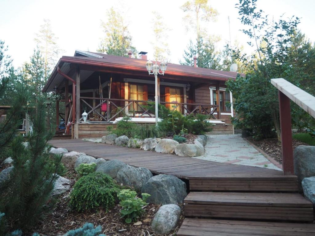 a house with a wooden deck in front of it at Villa Taikuri in Kyläniemi