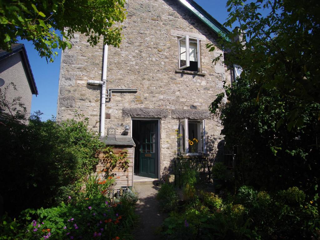 une maison en pierre avec une porte et une fenêtre dans l'établissement Bela Cottage, à Milnthorpe