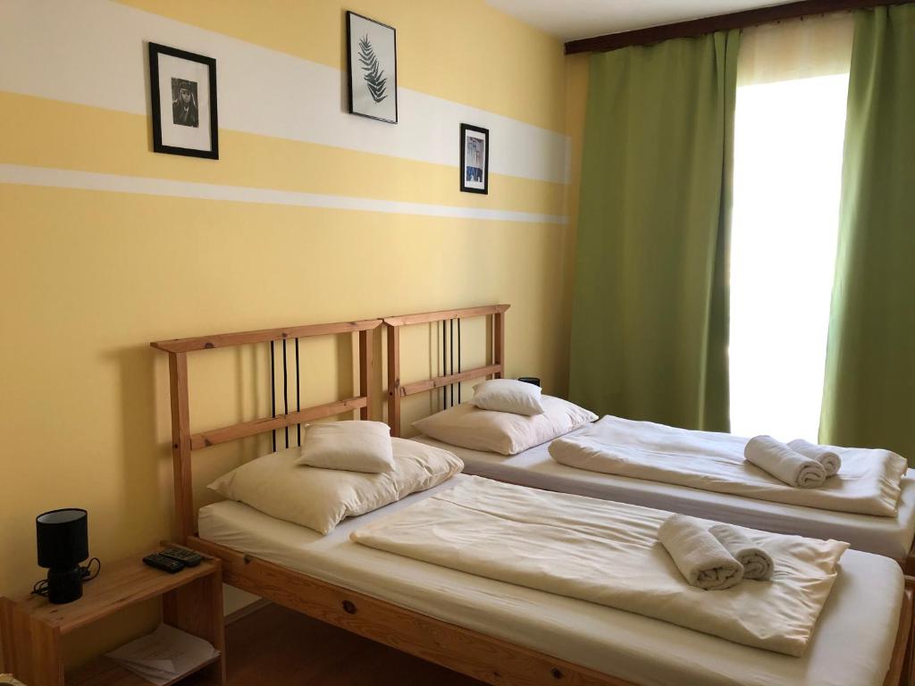 2 Betten in einem Zimmer mit Fenster in der Unterkunft Hotel Oroszlán Szigetvár in Szigetvár