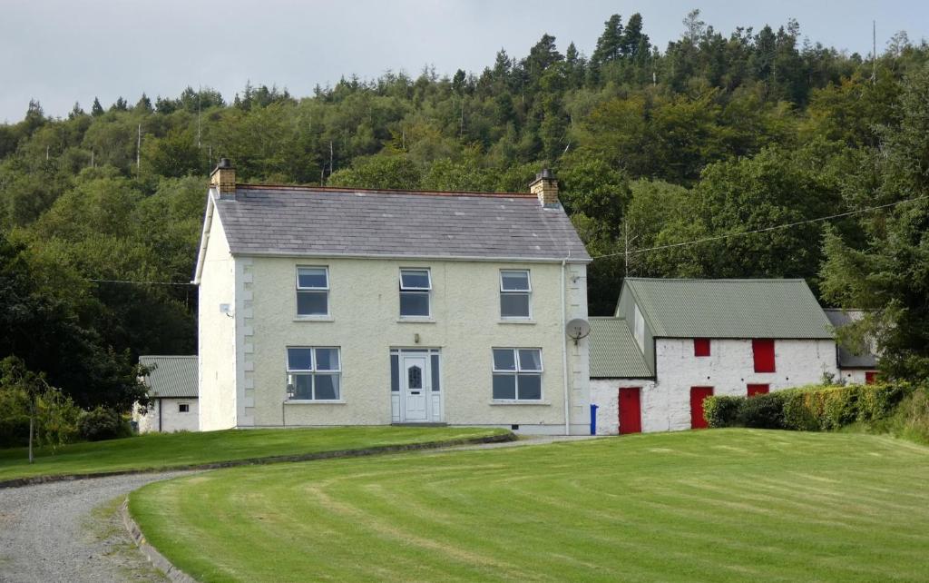 a house on a hill with a green yard at Alcorn's Farmhouse in Rathmullan