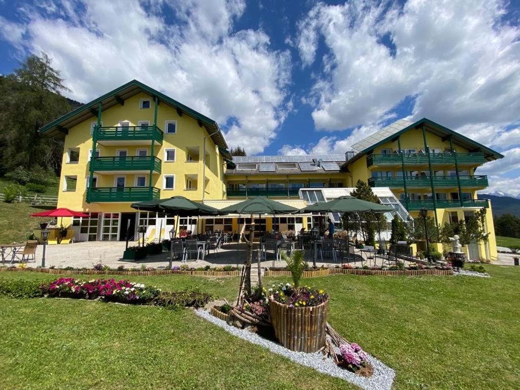 a large yellow building with a lawn in front of it at Hotel Belmont in Imst