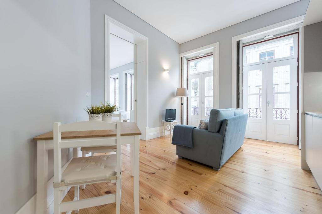 sala de estar con mesa y silla azul en LovelyStay - Porto Windows with AC by central station, en Oporto