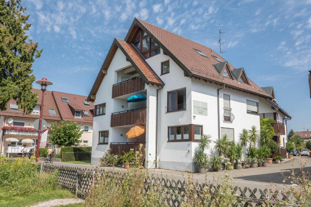 biały budynek z brązowym dachem w obiekcie Gästehaus Heinemann - Og4 w mieście Langenargen