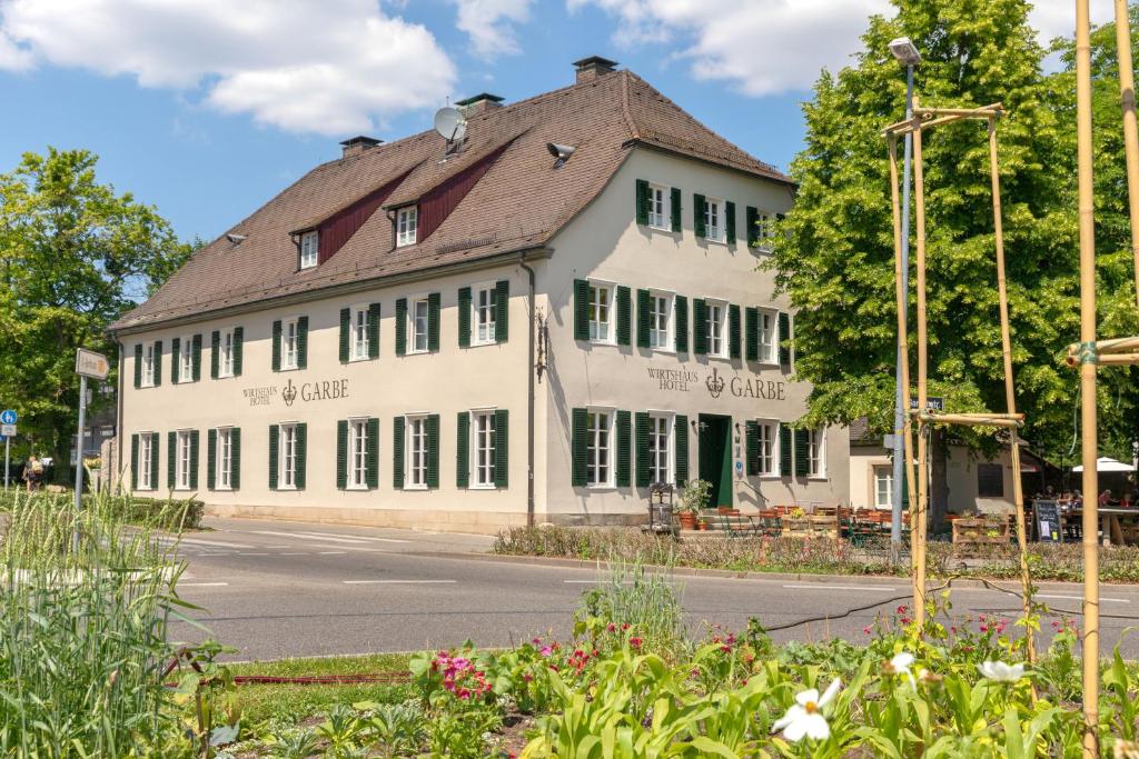 a large white building on the side of a street at Hotel Wirtshaus Garbe in Stuttgart