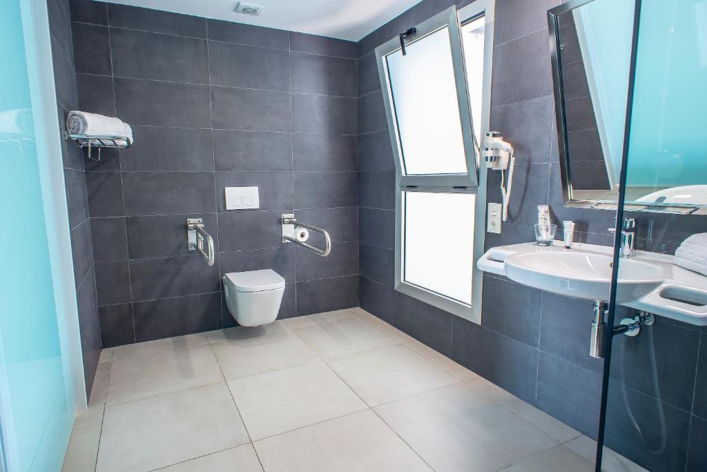 a bathroom with a toilet and a sink at Hotel Taimar in Costa Calma