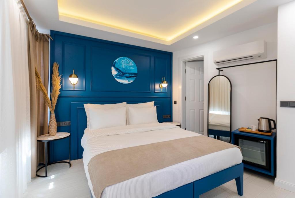 a bedroom with a large bed with blue walls at KIANA KALEİÇİ in Antalya