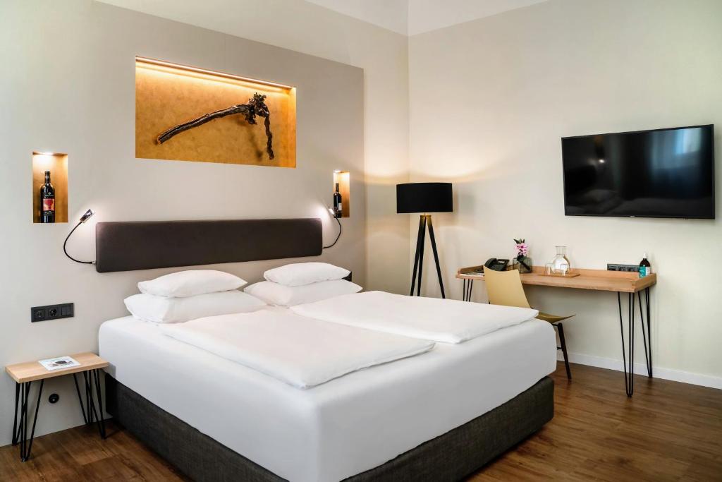 
a hotel room with a large bed and a television at Hotel Rathaus - Wein & Design in Vienna
