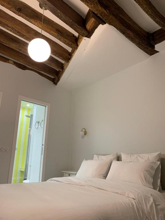 une chambre avec un lit blanc et un miroir dans l'établissement CHARMING Saint GERMAIN ODEON LUXEMBOURG, à Paris