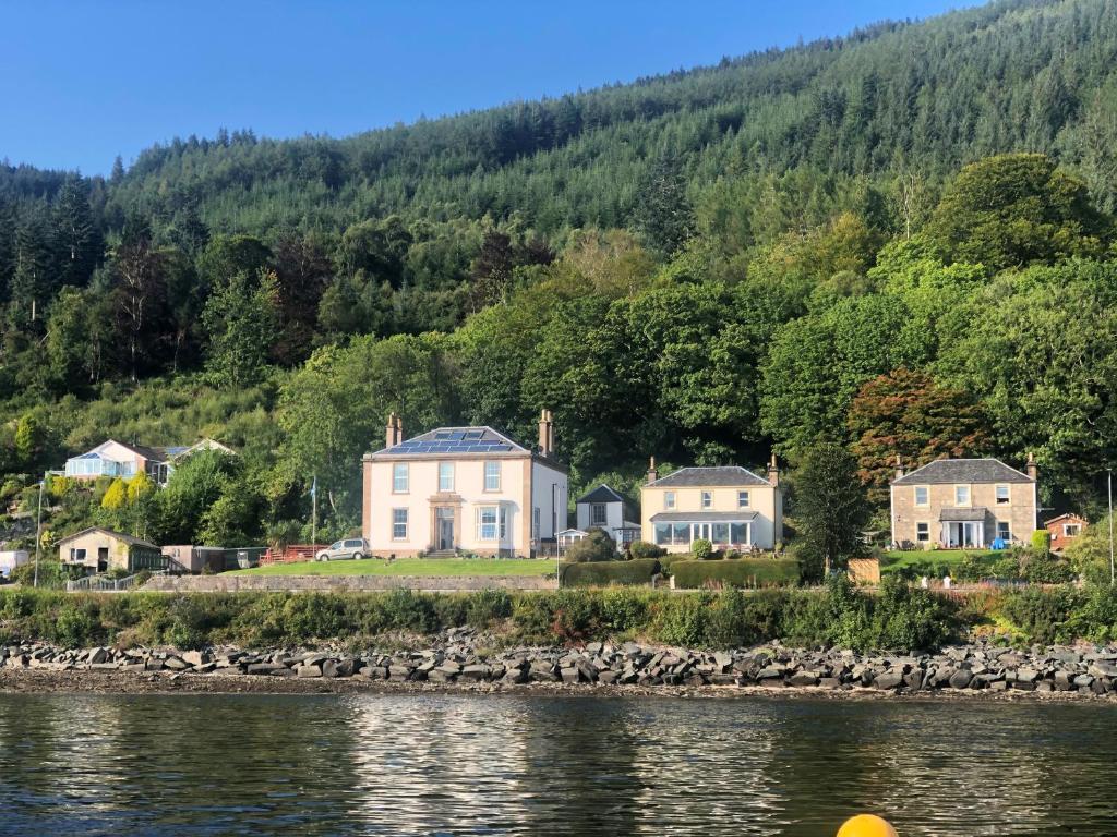 a group of houses on the shore of a body of water at Ardmun House in Dunoon