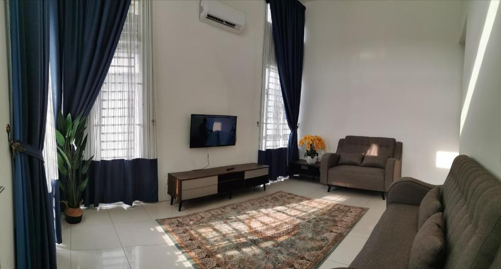 sala de estar con sofá, silla y TV en Damai Homestay Alor Setar en Alor Setar