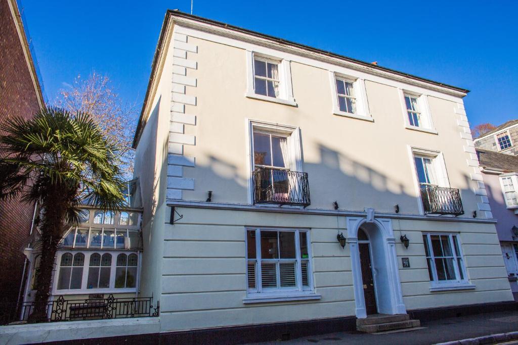 a white building with a palm tree in front of it at Ashburton Court in Ashburton