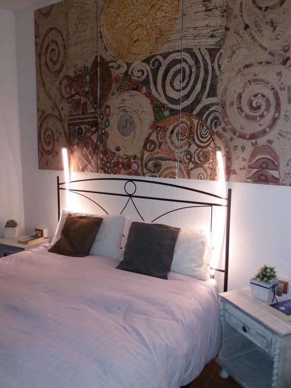 una camera da letto con un grande letto bianco con un muro di Lughera b&b a Tula