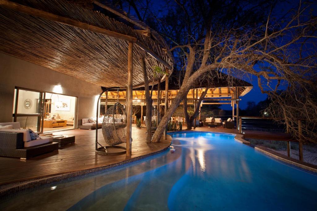 a resort with a swimming pool at night at Moditlo River Lodge in Hoedspruit