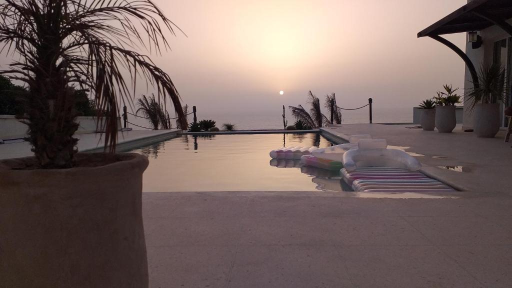 a swimming pool with a sunset in the background at La Casita in Essaouira