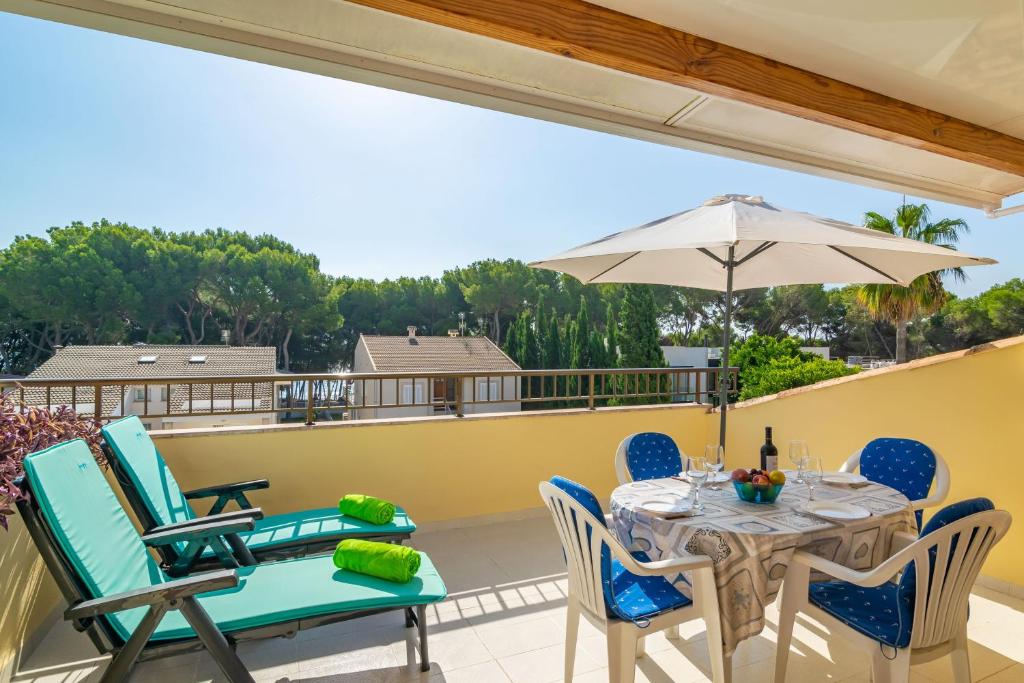 a patio with a table and chairs and an umbrella at Llepol in Port d'Alcudia