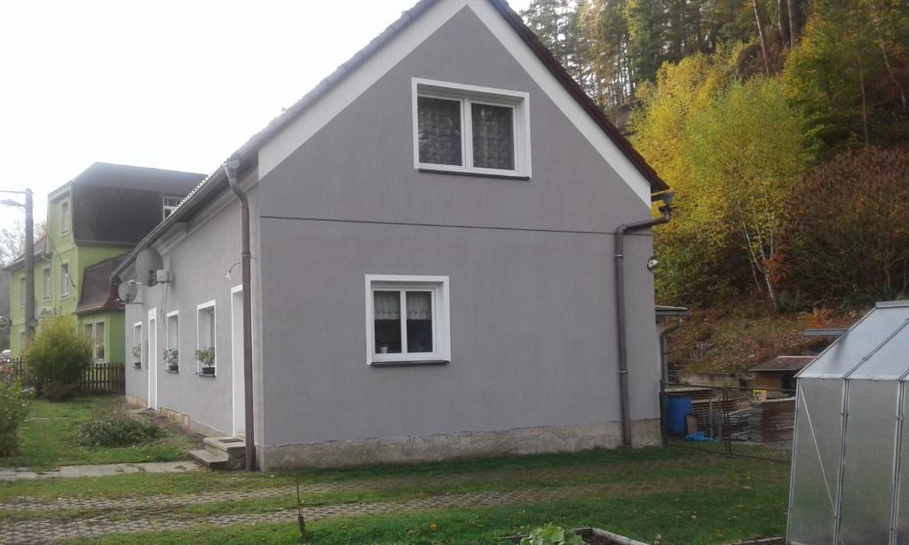 een wit huis met twee ramen en een tuin bij České Švýcarsko - Apartmán pro 2-3 dospělé osoby in Srbská Kamenice
