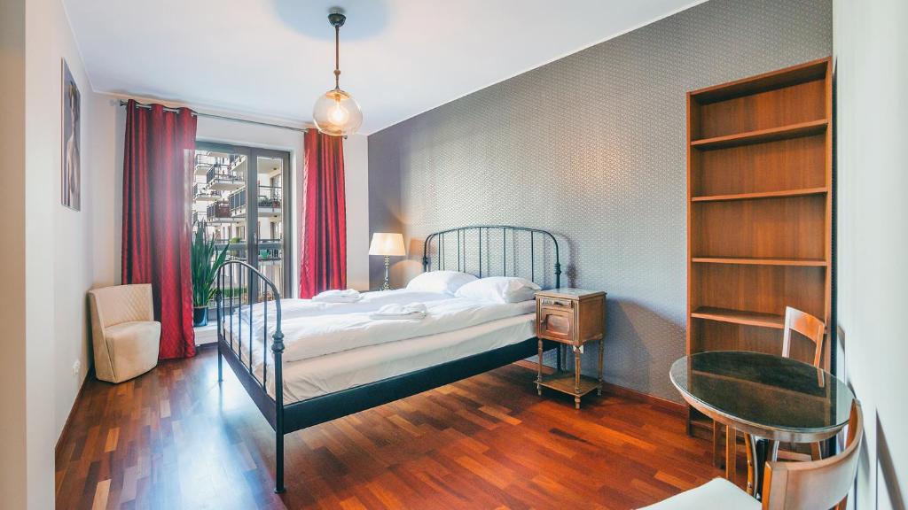 1 dormitorio con cama, escritorio y mesa en Apartamenty Sun & Snow Szafarnia en Gdansk