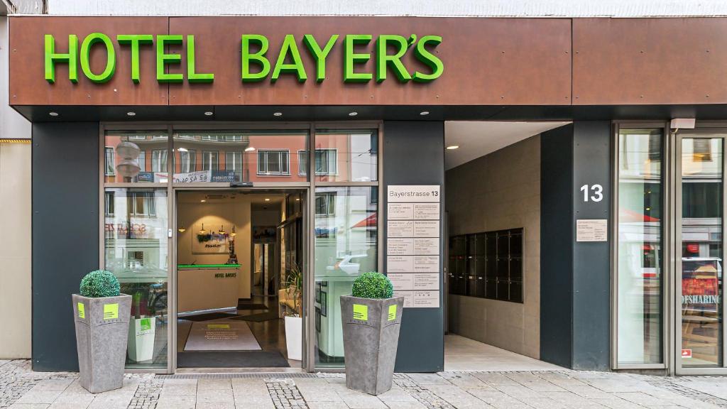 a hotel tavern with two potted plants in front of it at Hotel Bayer's in Munich
