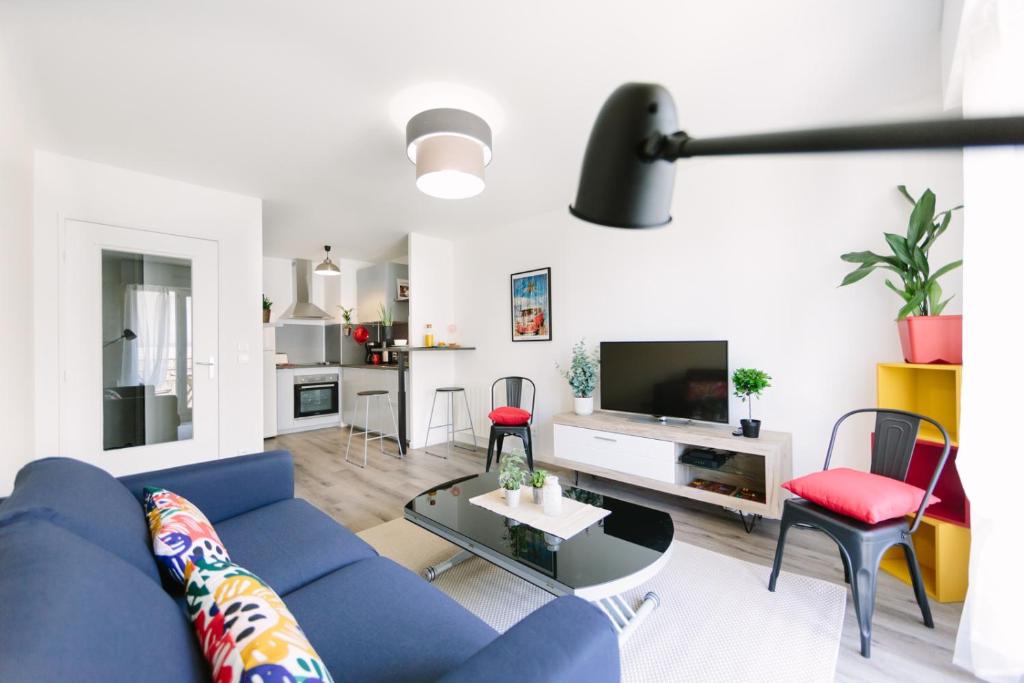 un salon avec un canapé bleu et une table dans l'établissement L'Idéal- Cité des Congrès, à Nantes