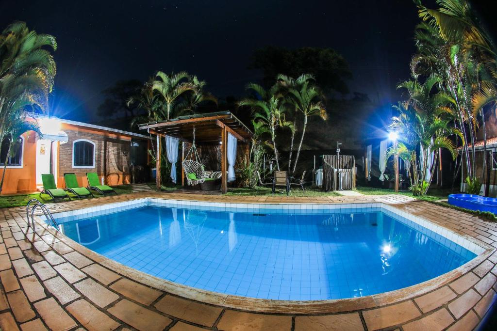 a swimming pool in a resort at night at Pousada Sonho Meu in Itanhandu