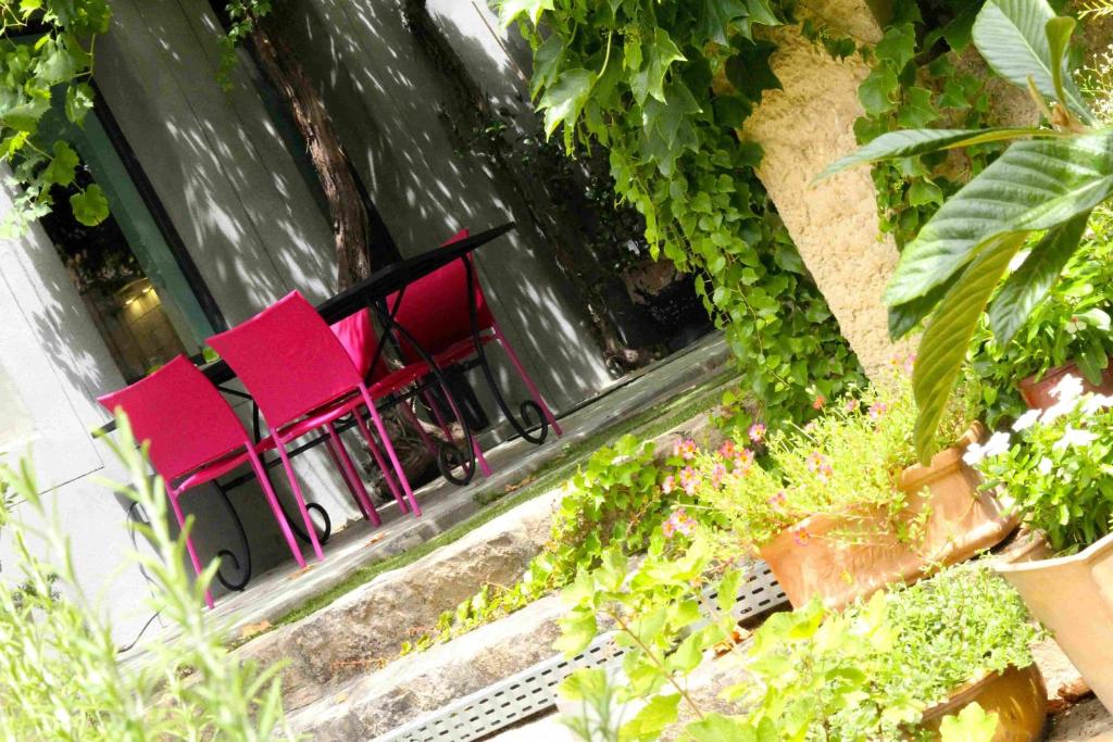 - un ensemble de chaises rouges assises sur un balcon dans l'établissement Maison d'Hôtes Côté Cour, à Rasteau