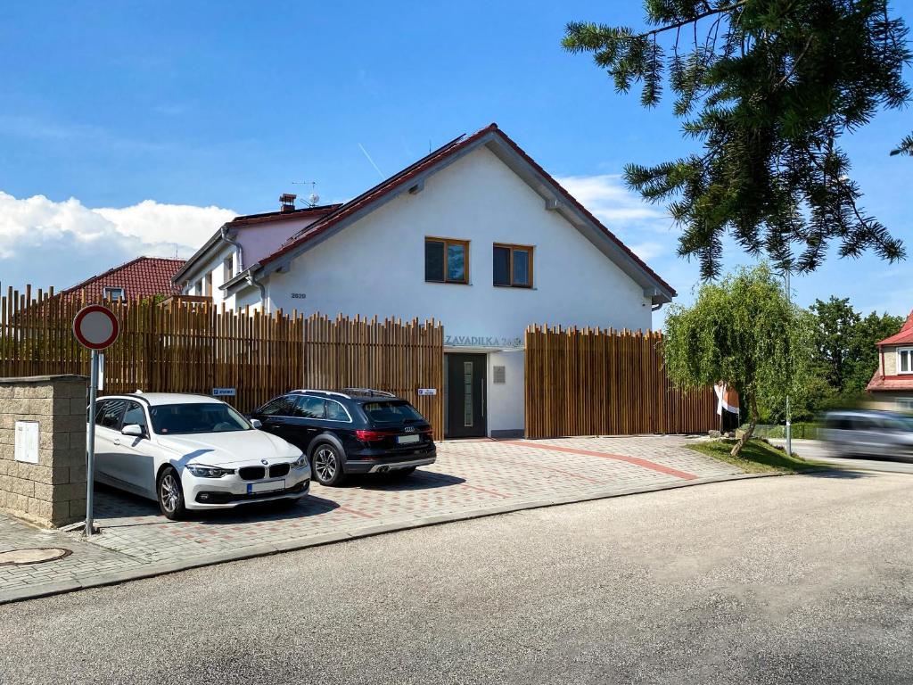 dos autos estacionados en un estacionamiento frente a una casa en Modern fully equipped studio with parking Zavadilka 2620 en České Budějovice
