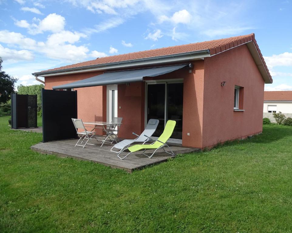 a house with a deck with chairs and a table at La Petite Maison in Ouches