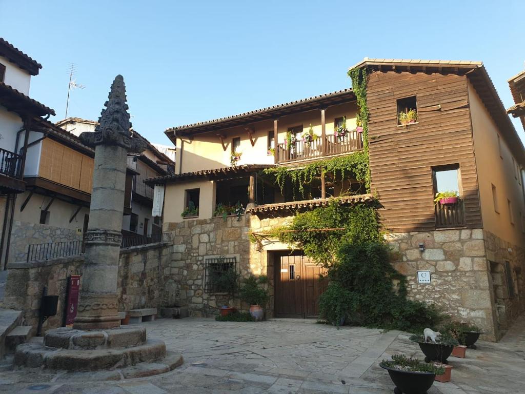 un edificio de piedra con un balcón en un lateral. en Casa Rural La Picota, en Valverde de la Vera