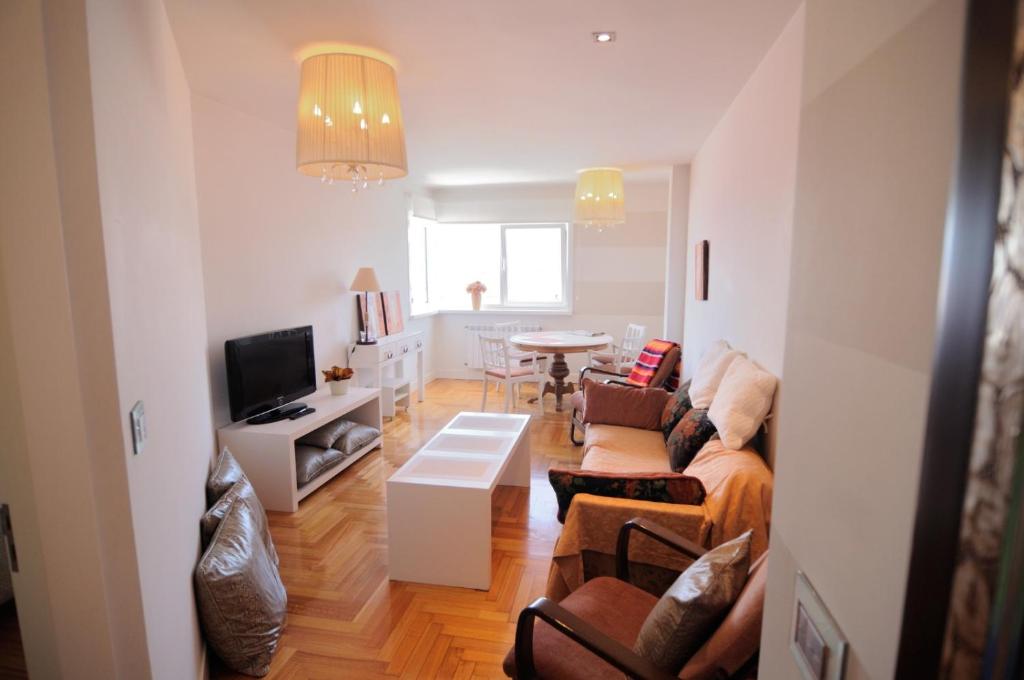 uma sala de estar com um sofá e uma mesa em Apartamento Vigo Centro con Garaje em Vigo