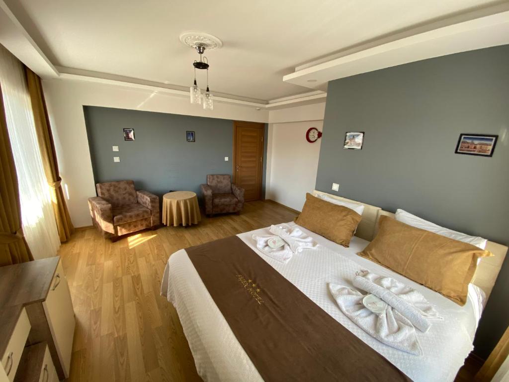 1 dormitorio con 1 cama grande y toallas. en Figen Hotel, en Canakkale