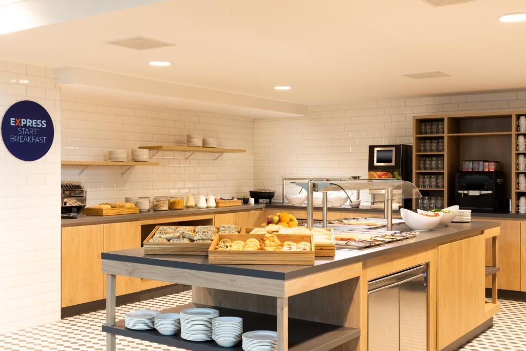 a kitchen with a table with food on it at Holiday Inn Express Amsterdam - North Riverside by IHG in Amsterdam
