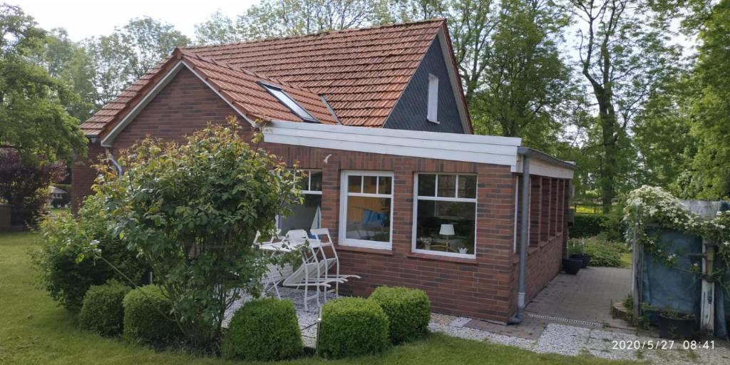 ein winziges Haus in einem Hof mit Fenster in der Unterkunft Ferienhaus Nordwind in Dornum